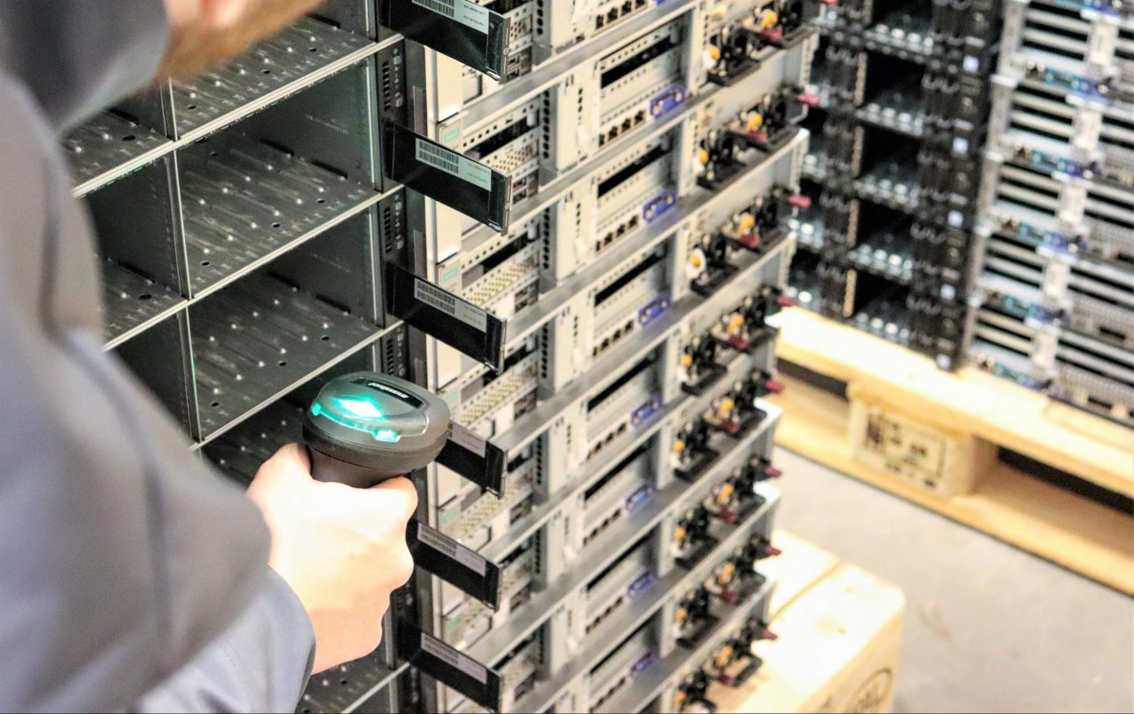 Scanning used server components behind a stack of refurbished servers for sale